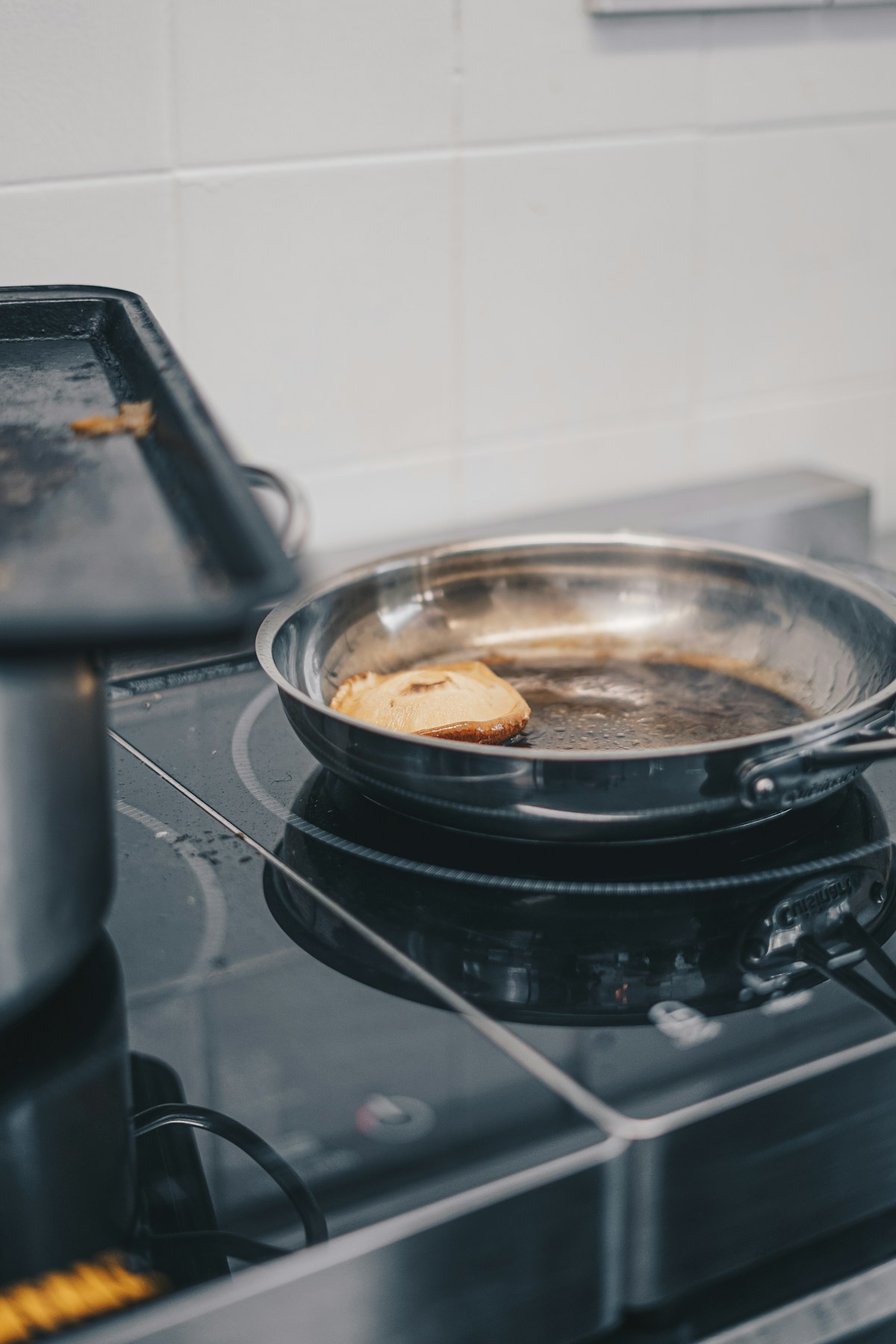 Roestvrijstalen koekenpan met eten op een glazen kookplaat